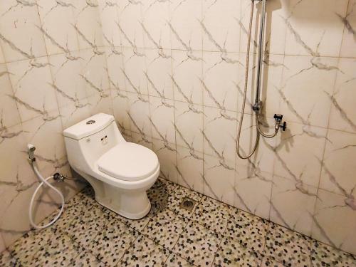 a bathroom with a toilet and a shower at RedDoorz near Stasiun Banyuwangi Kota in Glagah