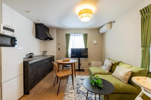 a living room with a couch and a table at Snow House LANKA in Furano