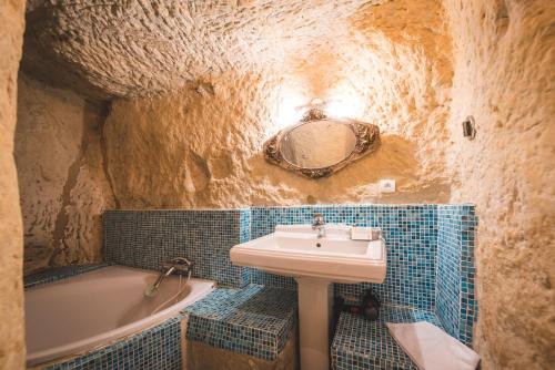 a bathroom with a sink and a bath tub at Logis Demeure de la Vignole in Turquant