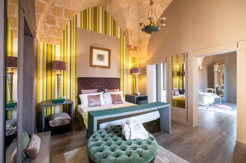 a bedroom with a bed with a green ottoman at Maison Boutique At Viviana in San Pietro in Lama