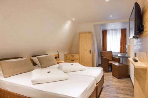 a hotel room with two beds and a desk at Gasthof zum Ochsen in Vöhrenbach