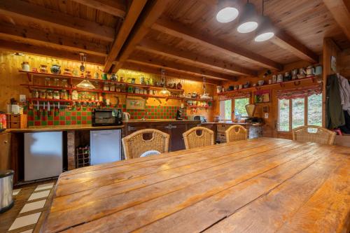 a large wooden table in a room with a bar at Le Chavot - Chalet 140 m² pour 8 personnes in Cohennoz