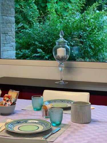 a table with plates and a wine glass on it at B&B Beauty House in Cesena