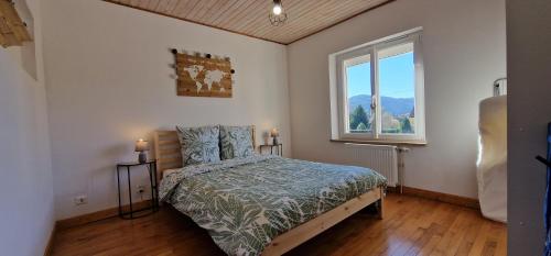 a bedroom with a bed and a window at La Maison des Montagnes in Le Thillot