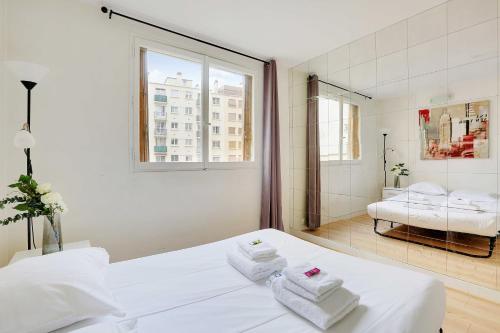 une chambre blanche avec un lit et un miroir dans l'établissement Charming apartment - 2BR-6P - Paris Expo, à Paris