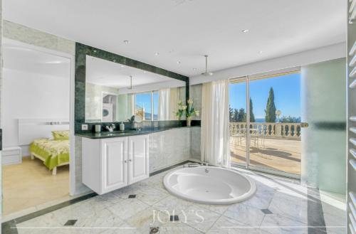 La salle de bains est pourvue d'un grand lavabo et d'une baignoire. dans l'établissement Villa d'architecte Super Cannes - Vue panoramique, à Cannes