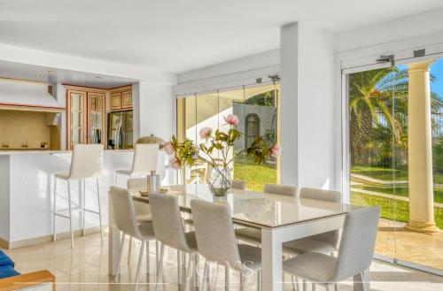 une salle à manger avec une table et des chaises en verre dans l'établissement Villa d'architecte Super Cannes - Vue panoramique, à Cannes