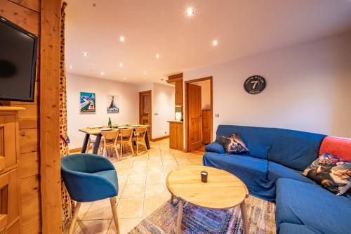 un salon avec un canapé bleu et une table dans l'établissement Alpine Garden - Truly hidden gem with sunny garden in Chamonix town center, à Chamonix-Mont-Blanc