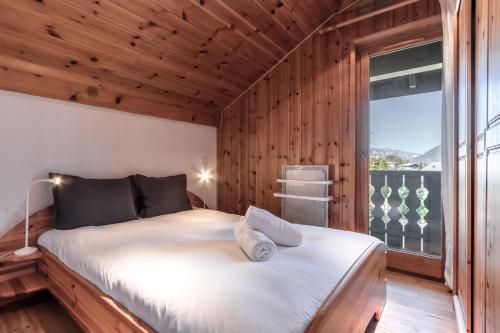 une chambre avec un grand lit avec une grande fenêtre dans l'établissement Appartement Edelweiss, à Saint-Gervais-les-Bains