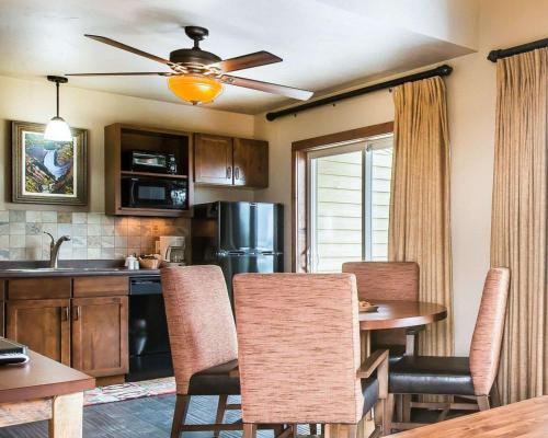 a kitchen with a table with chairs and a dining room at Yellowstone Valley Lodge, an Ascend Collection Hotel in Pray