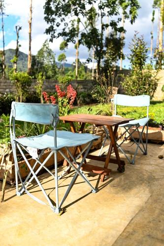 a table and two chairs sitting next to a wooden table at Kitanda Msituni in Meru