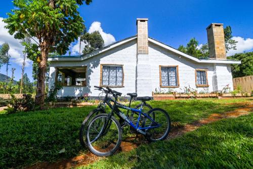 a bike parked in front of a white house at Kitanda Msituni in Meru