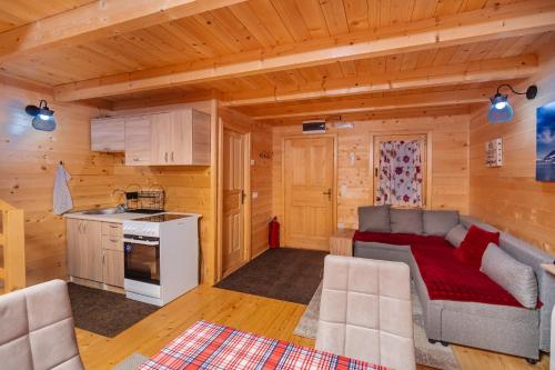 a living room and kitchen in a log cabin at Green Top with jacuzzi in Žabljak