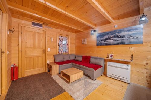 a living room with a couch in a log cabin at Green Top with jacuzzi in Žabljak