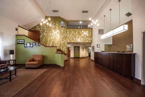 a lobby with a staircase with lights on the wall at Sleep Inn & Suites Tulsa Central I-44 in Tulsa