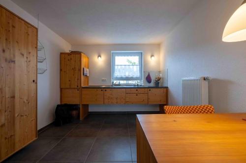 a kitchen with a wooden desk and a window at Ferienwohnung am Kurgebiet in Bad Waldsee