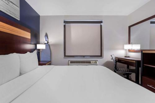 a hotel room with a bed and a desk and a computer at Avion Inn Near LGA Airport, an Ascend Collection Hotel in Queens