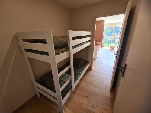 Cette chambre comprend 2 lits superposés dans un couloir. dans l'établissement Appartement Evasion Ensoleillée - Parking Jardin, à La Ciotat