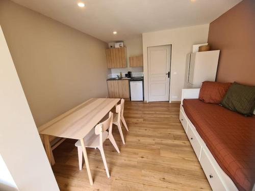 - une petite cuisine avec une table et un lit dans une chambre dans l'établissement Appartement Evasion Ensoleillée - Parking Jardin, à La Ciotat