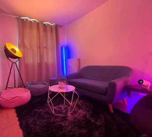 - un salon avec un canapé et une lumière violette dans l'établissement Échappée dans les étoiles, à Cergy