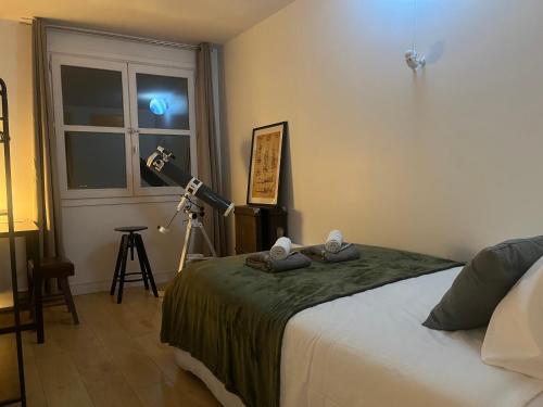 - une chambre avec un lit et un appareil photo sur un tripode dans l'établissement Échappée dans les étoiles, à Cergy