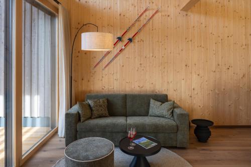 a living room with a couch and a clock on the wall at steiRerBLiCke - Wirtsalm Chalets in Pölsen