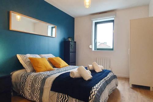 une chambre avec un grand lit avec un mur bleu dans l'établissement Cours de la Rep - 50m Gare et Tram, au Havre