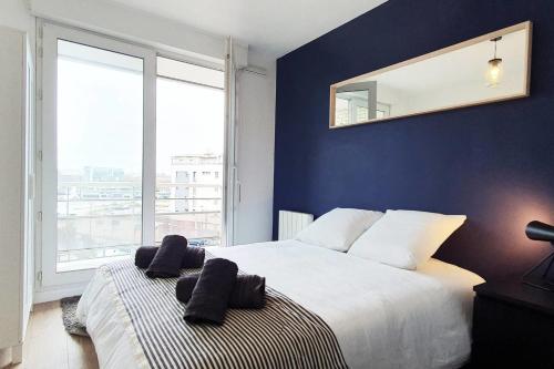 une chambre avec un grand lit avec un miroir au mur dans l'établissement Cours de la Rep - 50m Gare et Tram, au Havre
