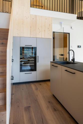 a kitchen with white cabinets and a sink at steiRerBLiCke - Wirtsalm Chalets in Pölsen