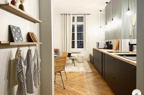 une cuisine avec des armoires en noir et blanc et une table dans l'établissement l'Exotique - Vue Pl Vieux Marché - Standing, à Rouen