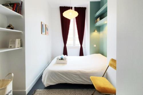 une petite chambre avec un lit et une chaise dans l'établissement L'Oasis Havrais - Centre Historique, au Havre