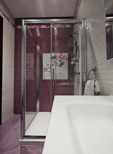 a shower with a glass door in a bathroom at The Sunset in Marsaskala