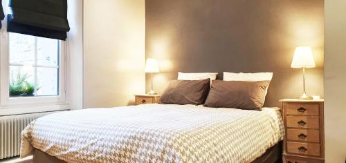 une chambre avec un lit avec deux lampes et une fenêtre dans l'établissement Place St Sauveur - Standing et Confort, à Caen