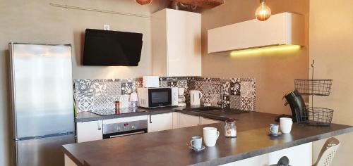 une cuisine avec un réfrigérateur et un plan de travail dans l'établissement Place St Sauveur - Standing et Confort, à Caen