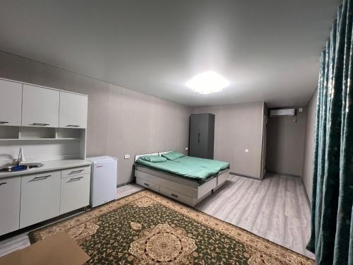 une petite chambre avec un lit et un lavabo dans l'établissement Tims cottage, à Karakol