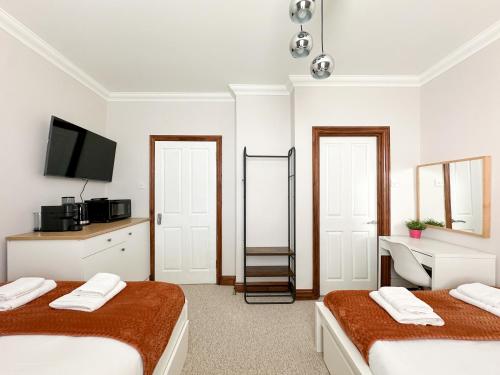 伦敦Fulham Rooms的白色的客房配有两张床和电视。