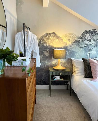 a bedroom with a bed and a table with a lamp at Boutique style cosy cottage in Ellesmere