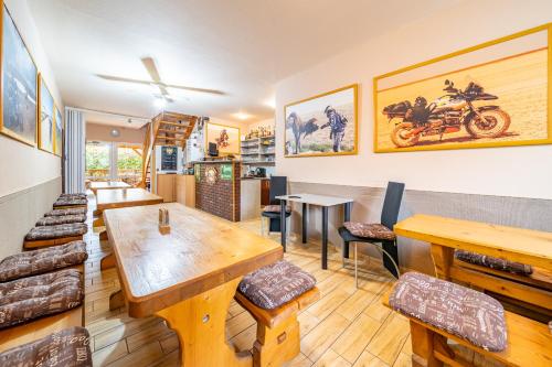 a restaurant with wooden tables and chairs and paintings on the wall at Penzion Flora in Konstantinovy Lázně