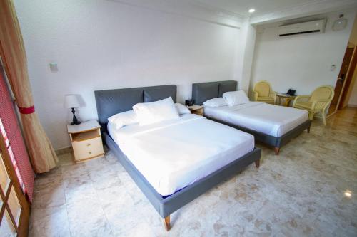 a bedroom with two beds and a table and chairs at Clarkton Hotel Apartment in Angeles