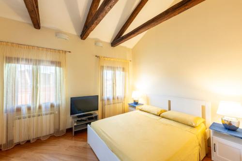 Un dormitorio con una cama y un televisor de pantalla plana. en Residenza San Piero, en Venecia