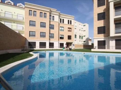 a large swimming pool in front of a building at Apartment T1 60 sq m for rent next to the bay in São Martinho do Porto