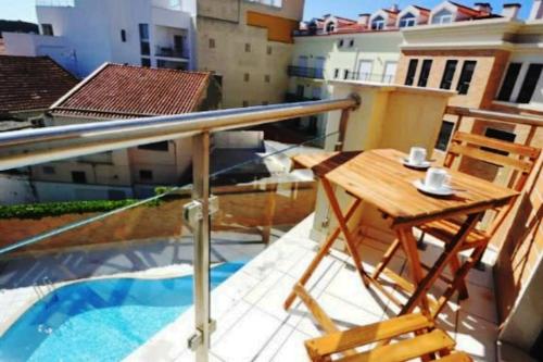 a balcony with a table and chairs on a roof at Apartment T1 60 sq m for rent next to the bay in São Martinho do Porto