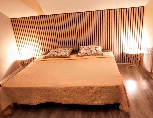 une chambre avec un grand lit avec deux tables de nuit dans l'établissement Appartement T2 ADOUR, à Bahus-Soubiran