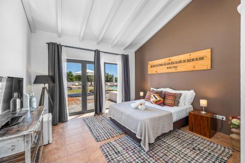 a bedroom with a bed and a large window at Tons da Terra - Casa de Campo & SPA in São Domingos