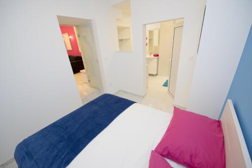 a bedroom with a bed with a blue and pink pillow at Apartment Dea II in Split