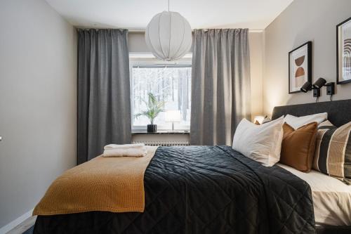 ルレオにあるGuestly Homes - 2BR Executive Apartment Modern & Stylishの大きなベッドと窓のある寝室