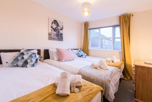 ein Schlafzimmer mit zwei Betten und einem Fenster in der Unterkunft Derby Dream 2 Bed Apartment - Close to City Center in Derby