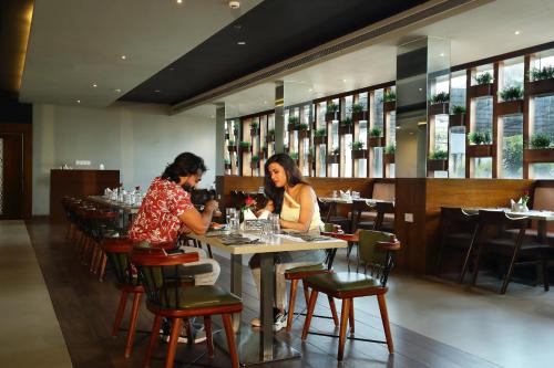 two women sitting at a table in a restaurant at Magnet Hotel in Kannur