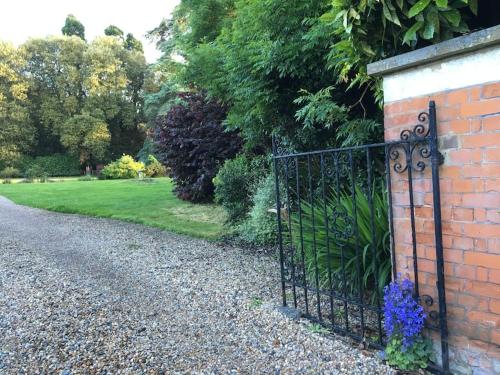 a iron gate on a brick wall next to a garden at Historical Country Retreat with Modern Amenities in Gravesend