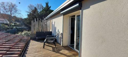 une chaise assise sur une terrasse à côté d'une maison dans l'établissement Petit appartement 2 chambres avec terasse dans villa grimaude, à Jacou